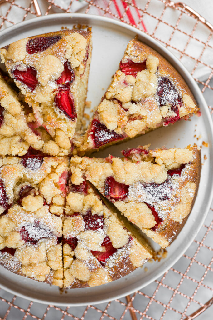 Bolo crumble de baunilha e morango fatiado, mostrando os pedaços de fruta e a cobertura crocante.