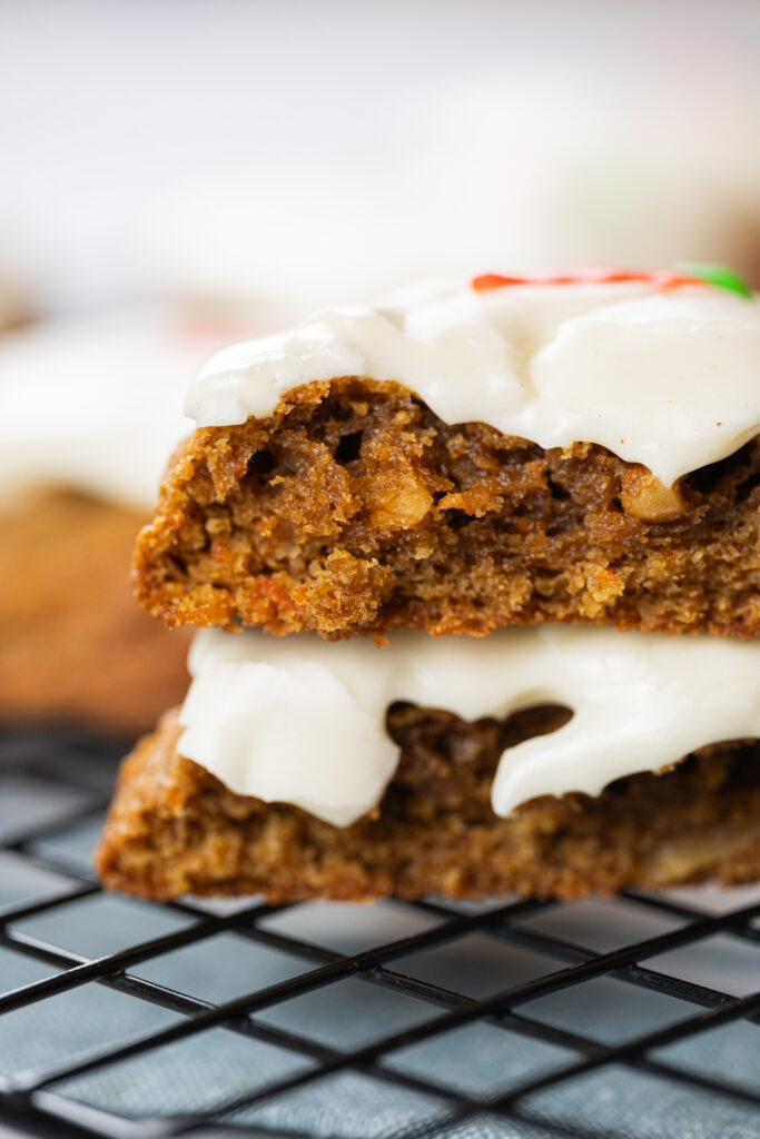 Close do interior úmido de carrot cake cookies com nozes, cenoura ralada e cobertura de cream cheese, empilhado em grade de resfriamento