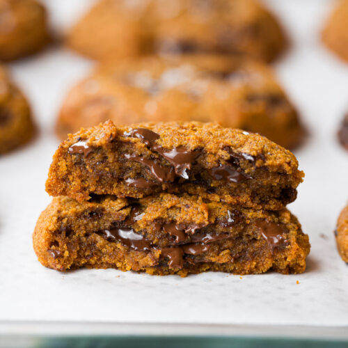 Cookie de gochujang partido ao meio, mostrando interior macio com chocolate derretido escorrendo.