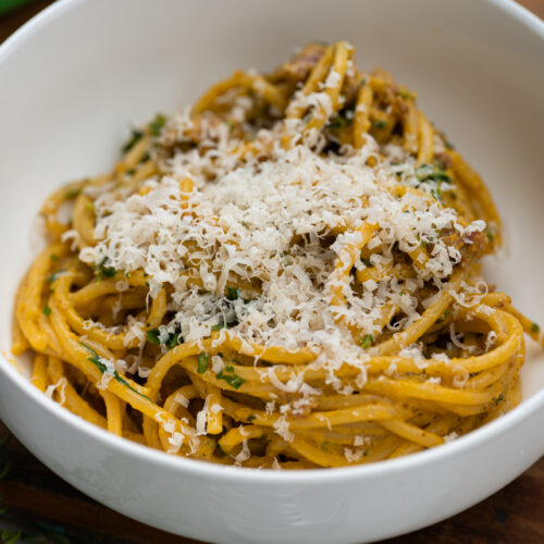 mac & cheese de abóbora com linguiça servido com parmesão ralado