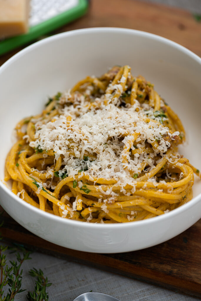 mac & cheese de abóbora com linguiça servido com parmesão ralado