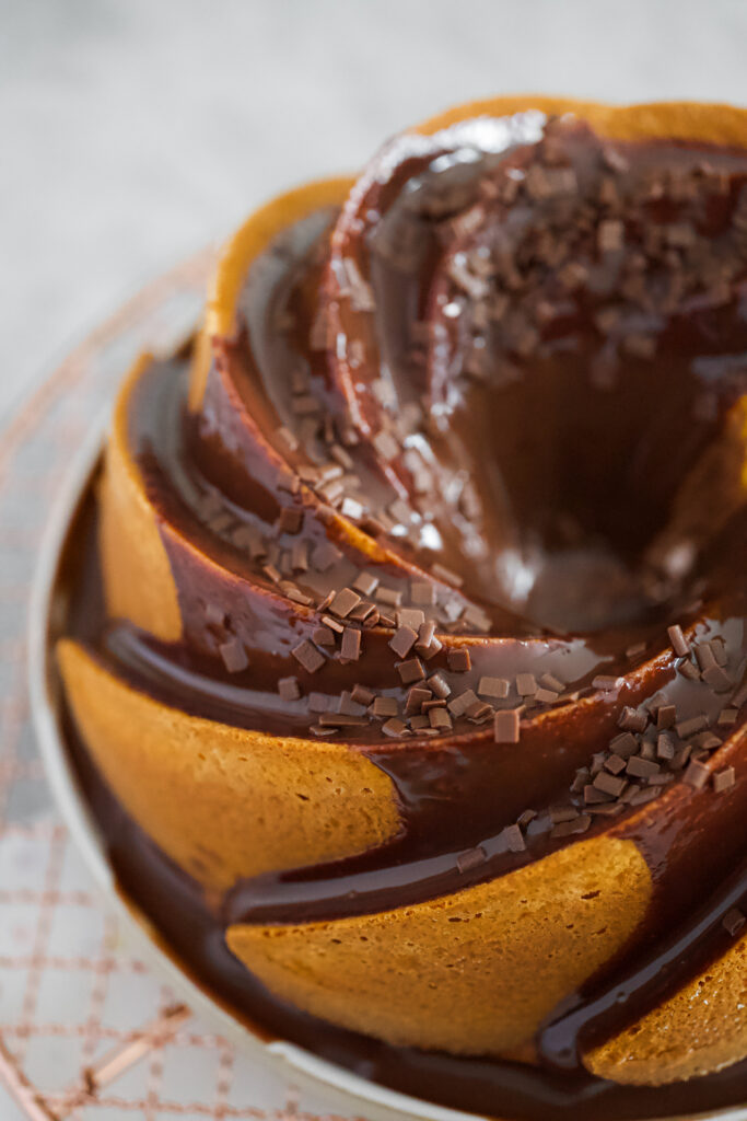 Bolo de cenoura com cobertura de chocolate brilhante escorrendo e granulado por cima