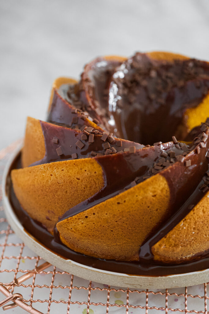 Bolo de cenoura com chocolate servido em prato com calda escorrendo